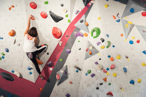 istock Woman practicing rock climbing on artificial wall indoors. Active lifestyle and bouldering concept. 927556208