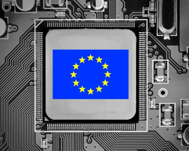 Macro photo of circuit board and chip with EU flag letters imprinted on metal surface