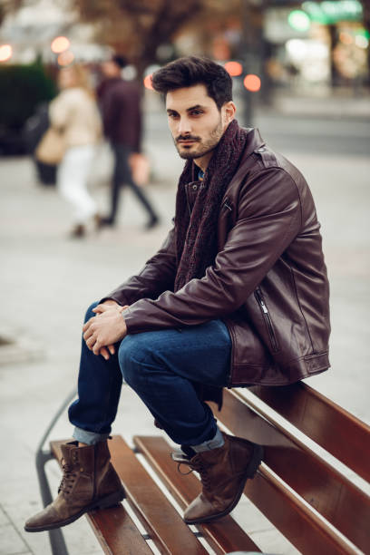 istock Thoughtful young man sitting on an urban bench. 927561622