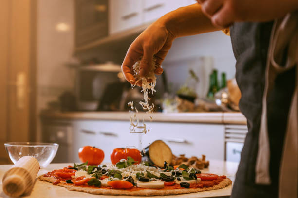 istock Woman adding healthy ingredients to pizza. 927561672