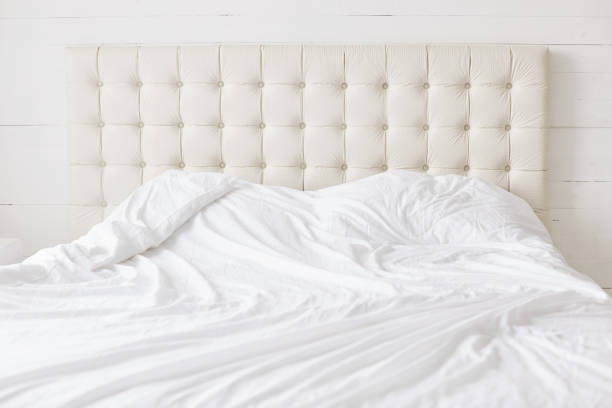 istock Empty bed with white soft duvet with nobody. Spacious bedroom and comfortable bed for your relaxation and rest. Bed time concept. Modern furniture in bedroom. 927564676