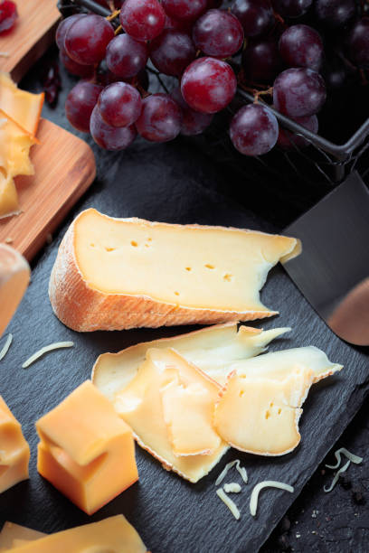 istock Black slate board with various cheese, decorated with grapes, bread and honey 927579218