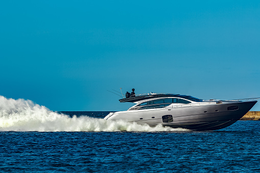 Grey speedboat moving fast by the river in Latvia. Water sport