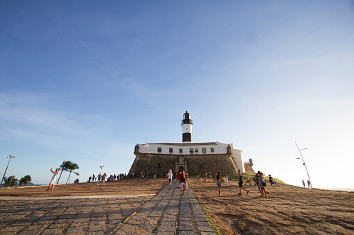 Salvador de Bahia, Brazil - May 14, 2017: Entrance to Barra Lighthouse at sunset with tourists who walk