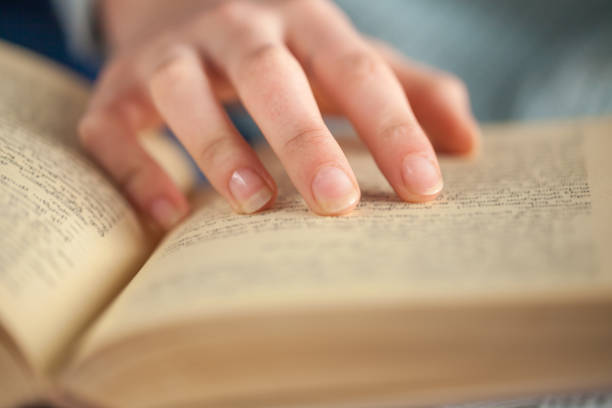 istock Young woman opening and reading a book, close up 927586164