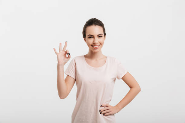 istock happy girl showing ok gesture isolated on white 927591780