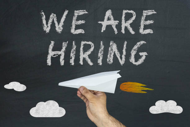 istock HR concept. Hand with plane and text: We are hiring. 927593950