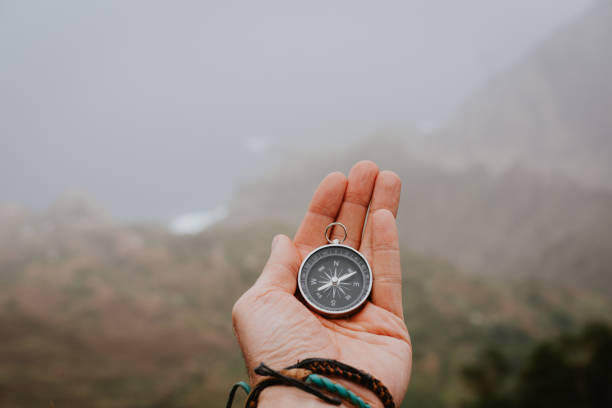 Photo of Looking at the compass to figure out right direction. Foggy valley and mountains in background. Santo Antao. Cape Cabo Verde