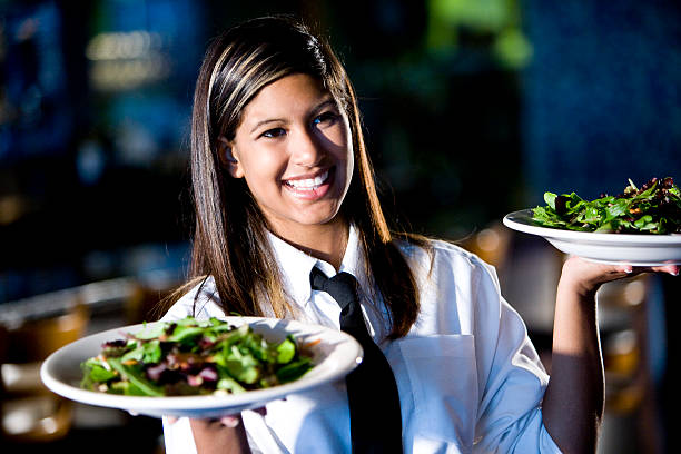 Happy friendly hispanic waitress serving salads  waitress stock pictures, royalty-free photos & images