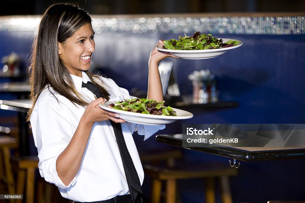 Happy hispanic waitress serving salads  Plate Stock Photo