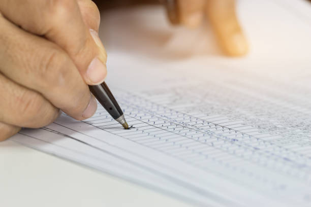 istock Hand Businessman holding pen for writing checking reports papers over application form. 927611464