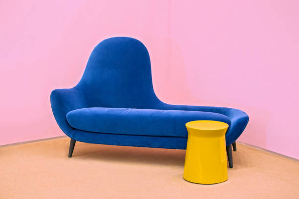 Navy blue sofa on a pink background, laconic interior