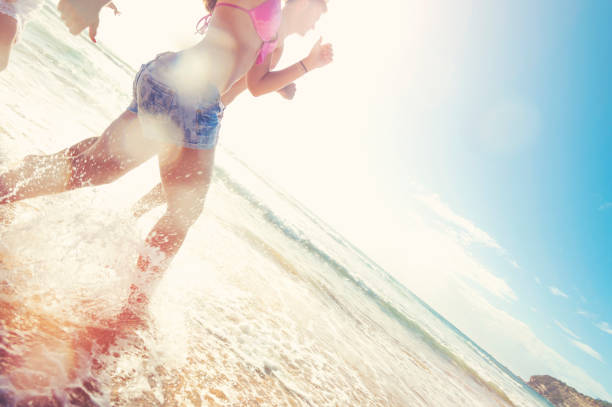 istock Smiling young people running on the beach in the sun. 927616822
