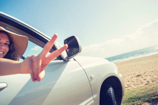 istock Young woman driving a car on the beach. 927616824