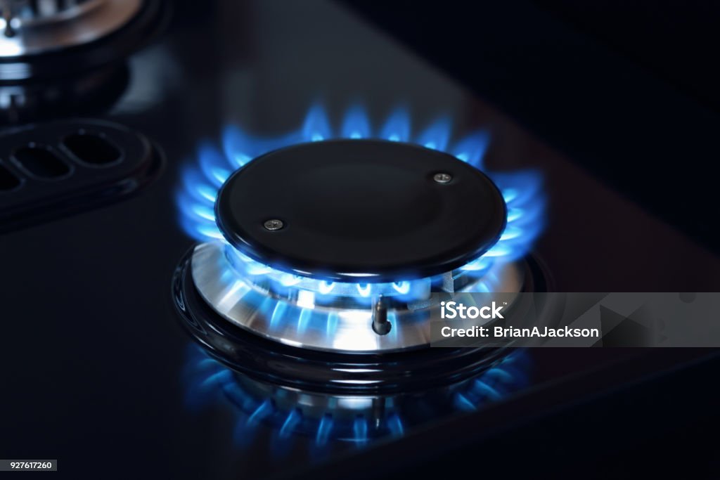 Natural gas burner flame on stove Natural gas burner flame on black stove Natural Gas Stock Photo