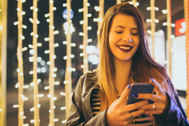 istock Young woman with mobile phone at night. 927619212