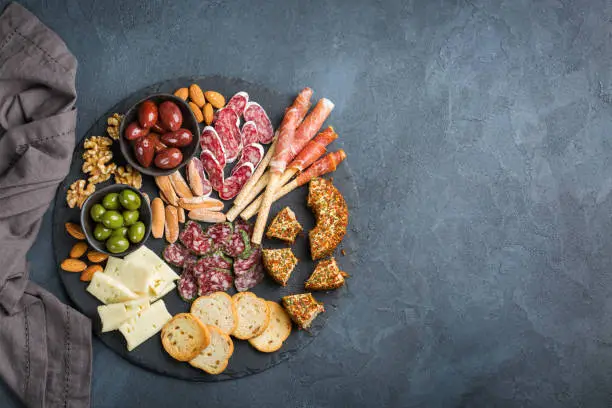 Photo of Assortment of spanish tapas or italian antipasti with meat