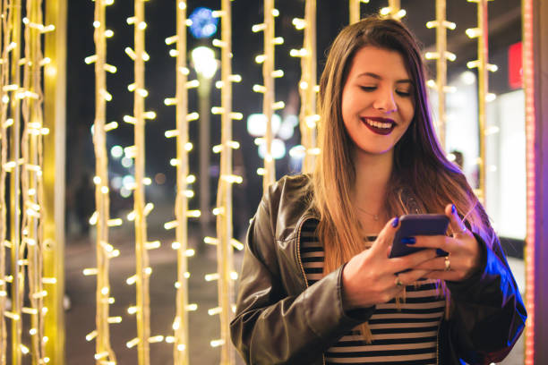 istock Young woman with mobile phone at night. 927619922