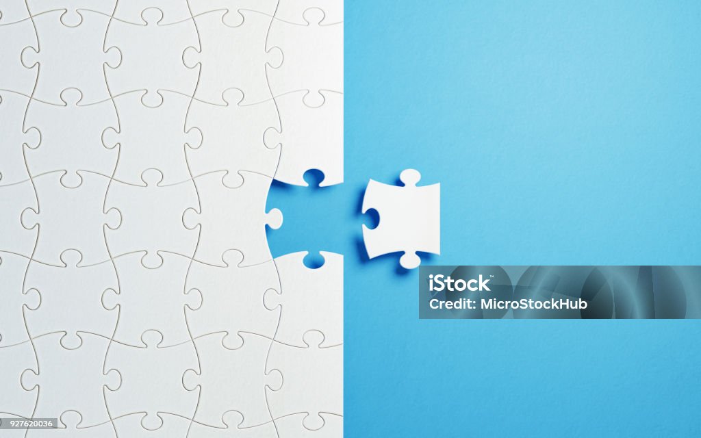 Puzzle Concept - White Jigsaw Puzzle Pieces On Blue Background White jigsaw puzzle pieces on blue background. Horizontal composition with copy space. Great use for puzzle concepts. Jigsaw Piece Stock Photo