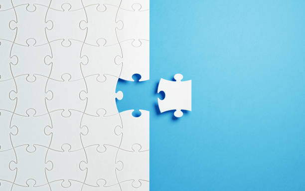 Puzzle Concept - White Jigsaw Puzzle Pieces On Blue Background White jigsaw puzzle pieces on blue background. Horizontal composition with copy space. Great use for puzzle concepts. jigsaw piece photos stock pictures, royalty-free photos & images