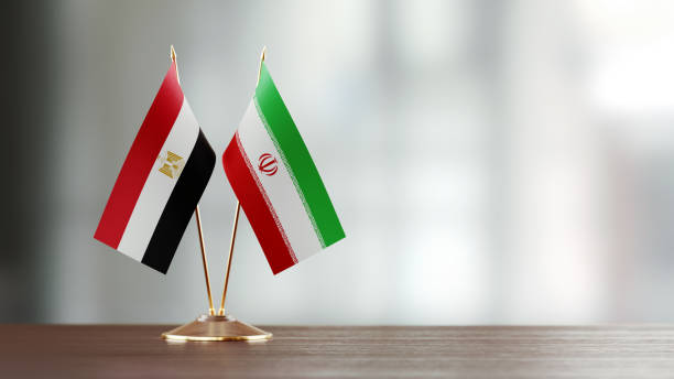 Egyptian And Iranian Flag Pair On A Desk Over Defocused Background