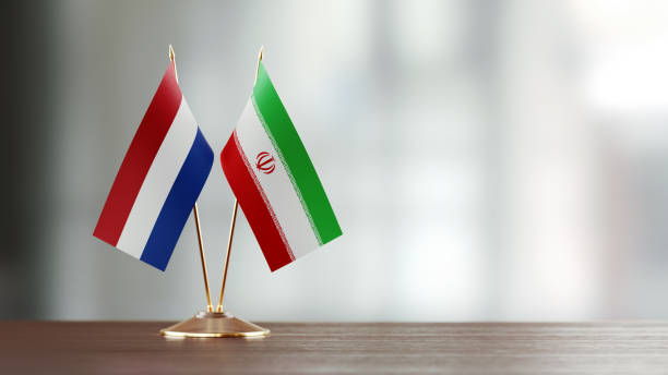 istock Dutch And Iranian Flag Pair On A Desk Over Defocused Background 927623174