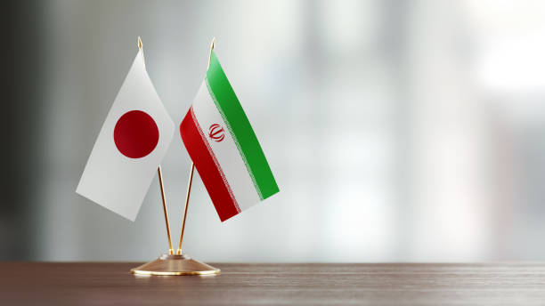 istock Japanese And Iranian Flag Pair On A Desk Over Defocused Background 927623416