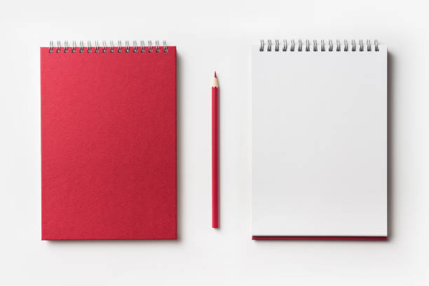 Top view of red spiral notebook and red pencil Design concept - Top view of red spiral notebook and color pencil collection isolated on white background for mockup handbook book hardcover book red stock pictures, royalty-free photos & images