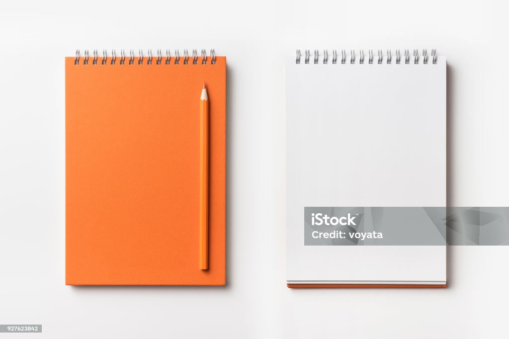 Top view of orange spiral notebook and color pencil collection Design concept - Top view of orange spiral notebook and color pencil collection isolated on white background for mockup Note Pad Stock Photo