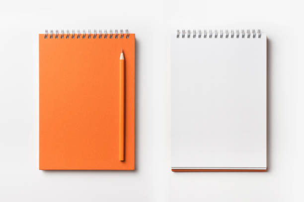 Top view of orange spiral notebook and color pencil collection Design concept - Top view of orange spiral notebook and color pencil collection isolated on white background for mockup note pad stock pictures, royalty-free photos & images