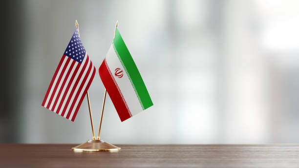 par de bandera americana e iraní en un escritorio sobre fondo defocused - iranian flag fotografías e imágenes de stock