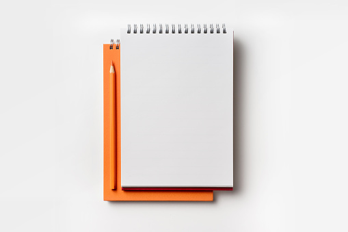 Vista superior de lápiz de color y cuaderno de espiral naranja photo