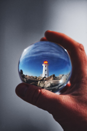 Peggy's Cove Lighthouse is refracted in a glass ball.