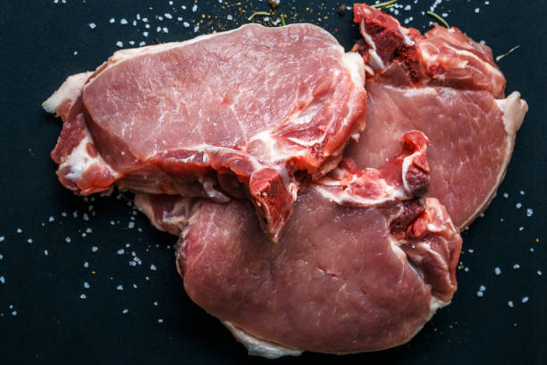 istock Raw meat, beef steaks on dark background, top view 927632818