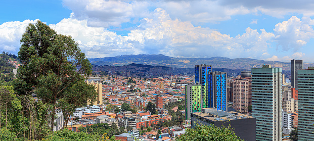 Bogota, Colombia - High angle view of the downtown district in the Andean capital city of Bogota, Colombia in South America, depicting the contrast between the old and the new. The red terracotta roof tiled buildings to the left of the image is La Candelaria, where the city was founded in 1538. It is the oldest part of the City. To the right, are modern concrete towers. Located at about 8500 feet above mean sea level, with a population of almost 10 Million, Bogota is one of the largest cities in Latin America. Photo shot in the morning sunlight; panorama created in Adobe Lightroom. The location from where the image was shot makes it an uncommon image: not many photographers will stop at the location with an expensive DSLR. The area is considered as high risk for mugging and even stabbing. Camera: Canon EOS 5D MII. Lens: Canon EF 24-70 F2.8L USM.