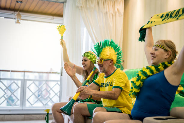 istock Brazilian fan watching soccer game at home 927653220