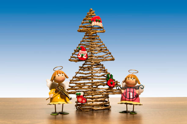 istock Christmas tree with two angels play music instruments 927656308