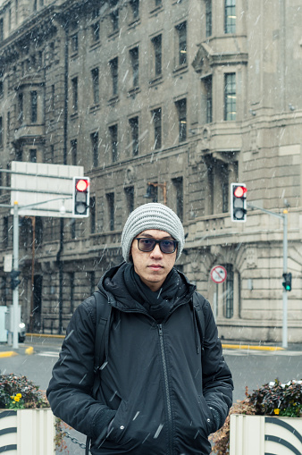 male tourist standing at the Bund, Shanghai in winter during snow