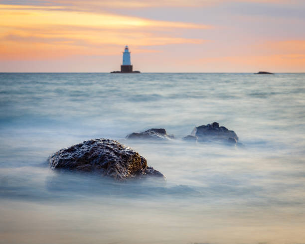 Silky Water Rocky Sunset Seascape with Lighthouse stock photo