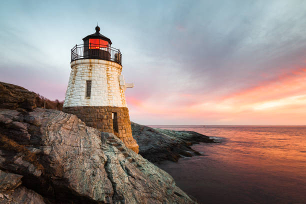 Castle Hill Lighthouse Landscape at Sunset Small Castle Hill Lighthouse sits on the rocky coastline of Newport, Rhode Island at sunset with the waves slowly rushing across the rocks. rhode island stock pictures, royalty-free photos & images