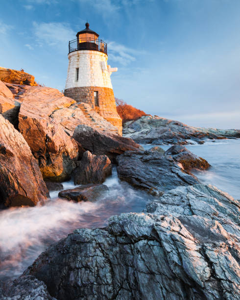 Castle Hill Lighthouse Landscape at Sunset Small Castle Hill Lighthouse sits on the rocky coastline of Newport, Rhode Island at sunset with the waves slowly rushing across the rocks. rhode island stock pictures, royalty-free photos & images