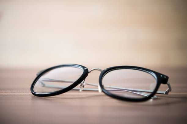 istock black glasses on wooden table. Close-up a black glasses. 927665146