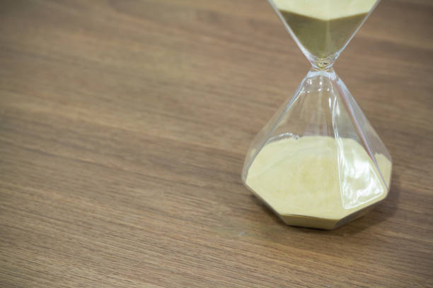 istock hourglass on wooden table free copy space for text 927669914