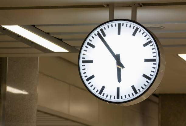 istock white clock hanging from ceiling, concept : hurry in early morning 927670096