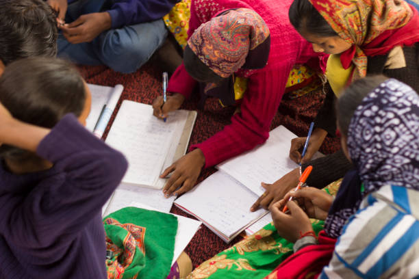 las niñas en la escuela de la aldea india estudian en un cirlcle, usar pañuelos cabeza - developing countries fotografías e imágenes de stock