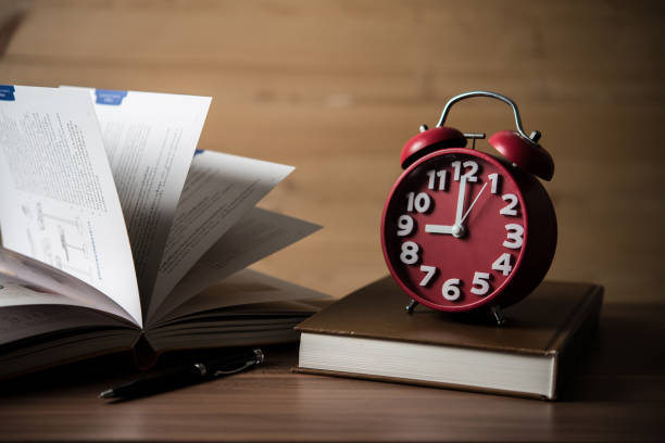 istock Books and alarm clock on wooden table. Education concept. 927676056