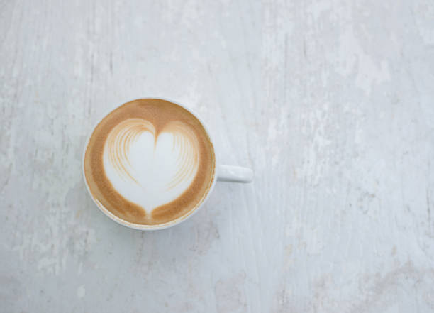 istock Cup of latte art heart shape coffee on white table. 927679078