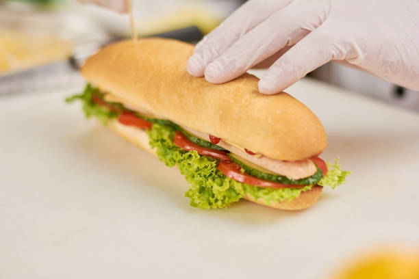 istock Chef hand press the hot dog close up. 927687556