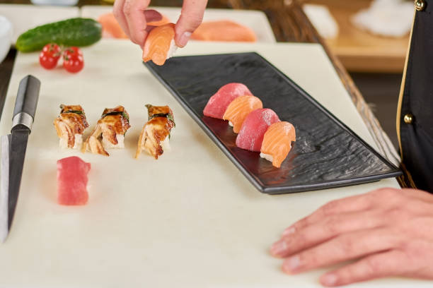 istock Chef putting sushi on black plate. 927687928