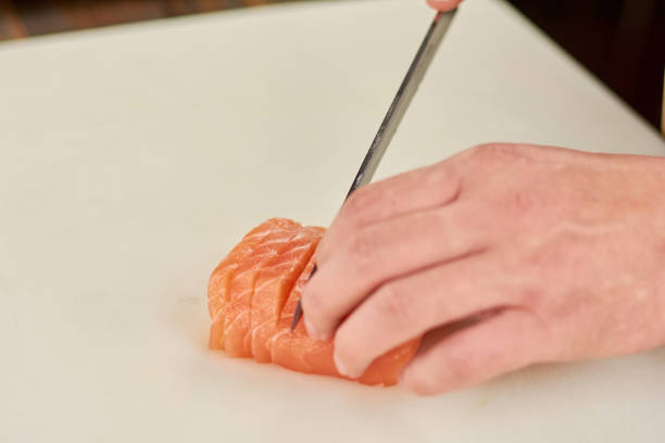istock Chef hand slicing salmon close up. 927688004